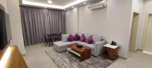a living room with a couch with purple pillows at أصالة الشروق حائل in Hail