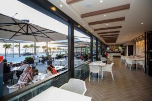 a restaurant with tables and people sitting at tables at Hotel Primavera in Vlorë