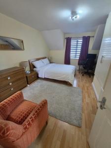 a bedroom with a bed and a couch and a chair at Gracian OMB Ongar 3 Bed in Dublin