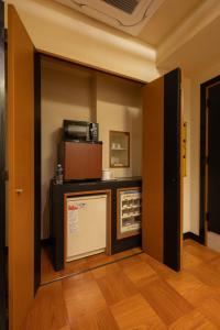a room with a kitchen with a microwave and a counter at ホテルリノ in Kitakyushu