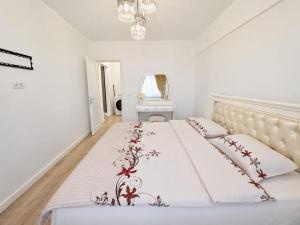 a bedroom with a white bed with red flowers on it at Abel 24 Residence in Bacău