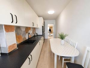 a kitchen with white cabinets and a small table at Abel 24 Residence in Bacău