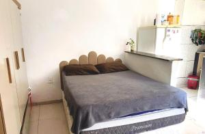 a bed in a small room with a refrigerator at Estúdio Centro 8 minutos da Lapa com Ar e cozinha equipada in Rio de Janeiro