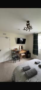 a bedroom with a bed and a table with a desk at Haste Ye Back in Inverness
