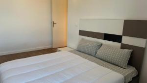 a bedroom with a large white bed with two pillows at Edifício Kings Tower T2-02 in Luanda +5 photos