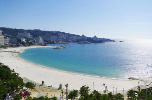 a beach with a group of people in the water at アドベンまで5分で4連棟の最大30名のゲストハウス in Shirahama