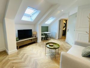 a living room with a couch and a tv at La PARENTHESE RUTHENOISE in Rodez