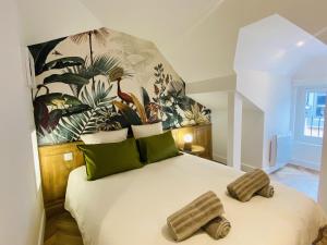 a bedroom with a large white bed with green pillows at La PARENTHESE RUTHENOISE in Rodez