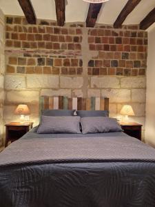 a bedroom with a bed in a brick wall at Le port des Chalands meublé de tourisme 3 étoiles in Saint-Georges-sur-Cher