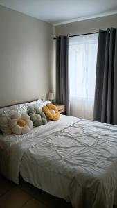 a bed with stuffed animals on it with a window at Keyspace condotel in Piapi +7 photos