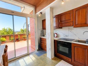 a kitchen with wooden cabinets and a large sliding glass door at Appartamento Turistico Monterotondo in Monterotondo
