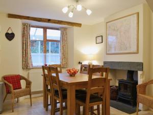 a dining room with a table and chairs and a fireplace at Beny Cot in Keswick