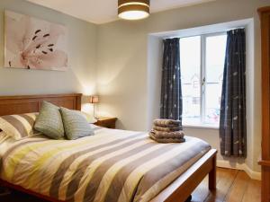 a bedroom with a bed and a window at Beny Cot in Keswick +12 photos