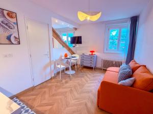 a living room with an orange couch and a table at Studio cosy proche des Thermes in Royat