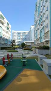 a playground in a parking lot with tall buildings at Keyspace condotel in Piapi