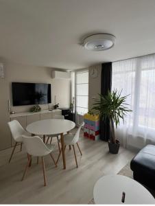 a living room with a table and chairs at Pool & Chill Balaton in Balatonvilágos