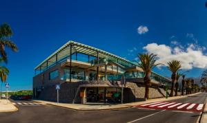 a large building with palm trees in front of it at Gorgeous Paraiso FREE WIFI by Olax Rentals in Playa Paraiso
