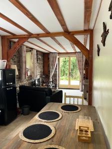 a living room with a wooden table in a room at Chez Jallot - Lower Gite in Vidaillat