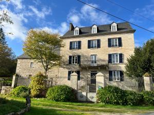 an old stone house with a black roof at Chez Jallot - Lower Gite in Vidaillat