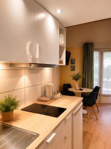 a kitchen with white cabinets and a table with chairs at Résidence Thibaud in Toulouse