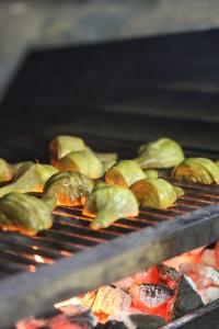 a bunch of food is cooking on a grill at Hotel Restaurant Mas Roig - Adults only in Pals