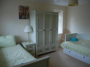 a bedroom with two beds and a cabinet and a lamp at Shallcross Hall Cottage - Toddbrook - Whaley Bridge in Taxal