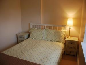 a bedroom with a bed and two night stands with a lamp at Shallcross Hall Cottage - Toddbrook - Whaley Bridge in Taxal