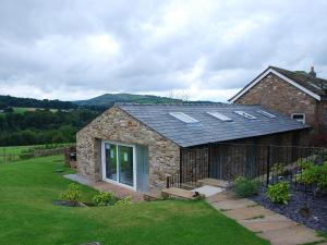 a stone house with solar panels on the roof at Shallcross Hall Cottage - Toddbrook - Whaley Bridge in Taxal +3 photos