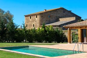 a house with a swimming pool in front of a building at Hotel Restaurant Mas Roig - Adults only in Pals