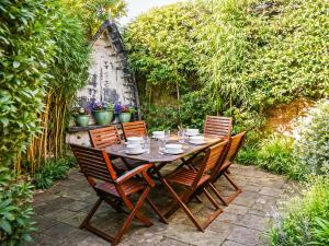 a wooden table and chairs in a garden at Starboard Cottage in Winterton-on-Sea +27 photos