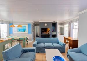 a living room with blue couches and a table at Helios House in Langebaan