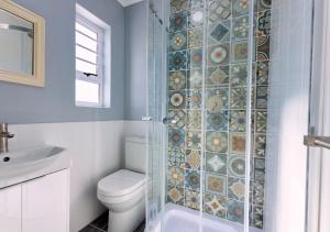 a bathroom with a toilet and a glass shower at Helios House in Langebaan +24 photos
