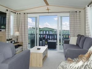 a living room with two couches and a large window at Premier Caravan 10 in Tywyn