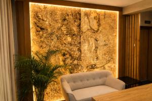 a living room with a white chair and a wall at Ruciane Residence in Ruciane-Nida