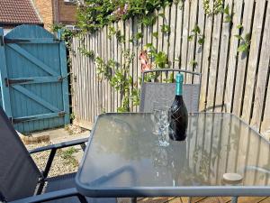 a bottle of wine sitting on a table with a glass at Twenty One in Westward Ho