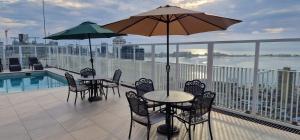 two tables and chairs with umbrellas on a balcony at Edifício Kings Tower T2-06 in Luanda