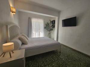 a bedroom with a bed and a television on the wall at Villa Palmer in Paguera