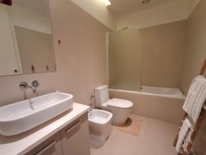 a bathroom with a sink and a toilet and a tub at Edifício Kings Tower T2-06 in Luanda +5 photos