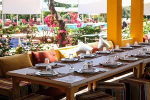 a long table with plates and napkins on it at Domaine Couleurs Berbères, Piscine, Vue Atlas, Bivouac & Expériences à Lalla Takerkoust in Lalla Takerkoust