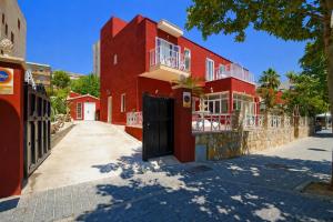 a red building with a black door on a street at Villa Palmer in Paguera