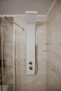 a bathroom with a shower with a glass door at The Lighthouse Sunset View Suites in Akrotiri +25 photos