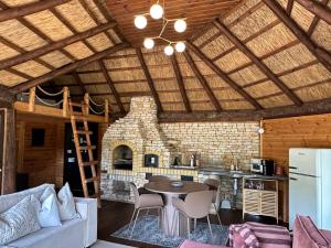 a kitchen and living room with a wooden ceiling at Cabin by the pond in Wądołki Bućki