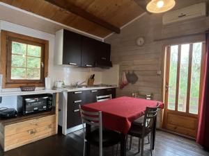 a kitchen with a table with a red table cloth at Holiday Home Le Terrazze del Geco Bungalow B - SLR301 by Interhome in San Lorenzo al Mare