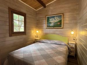 a bedroom with a bed in a wooden room at Holiday Home Le Terrazze del Geco Bungalow B - SLR301 by Interhome in San Lorenzo al Mare