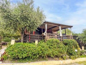 a house with a porch and a tree at Holiday Home Le Terrazze del Geco Bungalow A - SLR300 by Interhome in San Lorenzo al Mare