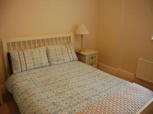 a bedroom with a bed and a night stand with a lamp at Shallcross Hall Cottages - Combs in Taxal