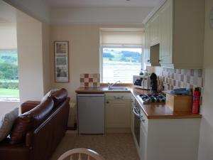 a kitchen with a sink and a counter top at Shallcross Hall Cottages - Combs in Taxal