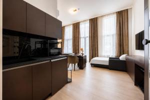 a room with a kitchen and a bedroom with a bed at GemStay Antwerp in Antwerp