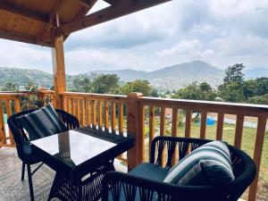 a patio with a table and chairs on a deck at The Walnut Homes- Luxury Pine Cottages in Bhīm Tāl +6 photos