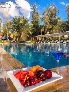 a plate of vegetables on a table next to a swimming pool at Domaine Couleurs Berbères, Piscine, Vue Atlas, Bivouac & Expériences à Lalla Takerkoust in Lalla Takerkoust